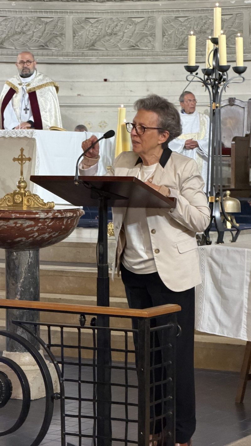 Caroline de Raimond parle au pupitre de l'église ; derrière elle, un prêtre en ornements maronites et un autre célébrant.